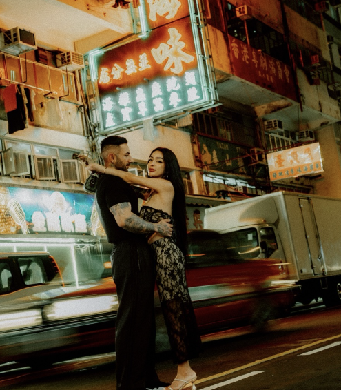 A couple embracing on a neon-lit street