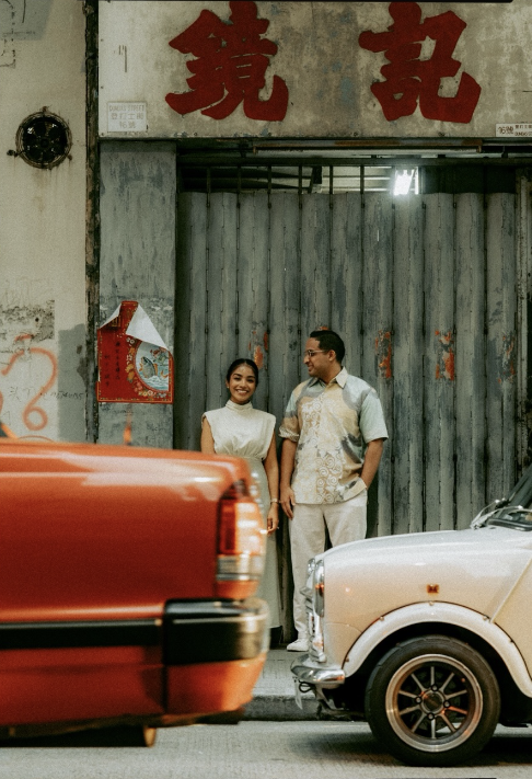 A couple standing between taxis