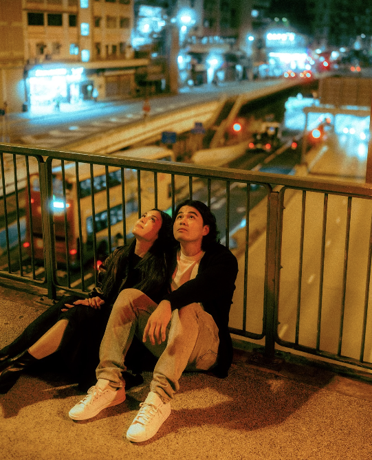 A couple on an overpass at night
