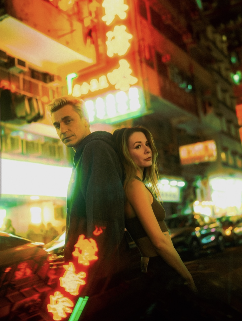 Two people in reflected neon light