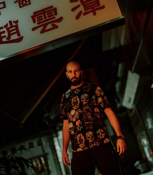 A portrait beneath a lit night sign