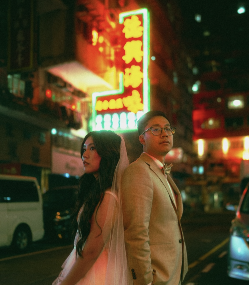 A couple on a neon-lit street